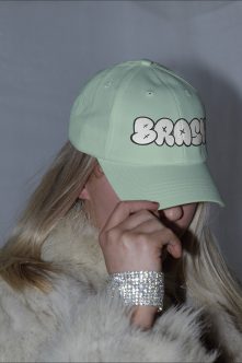 Mint baseball cap side view with bubble letter BRASH design featuring X cross eyes